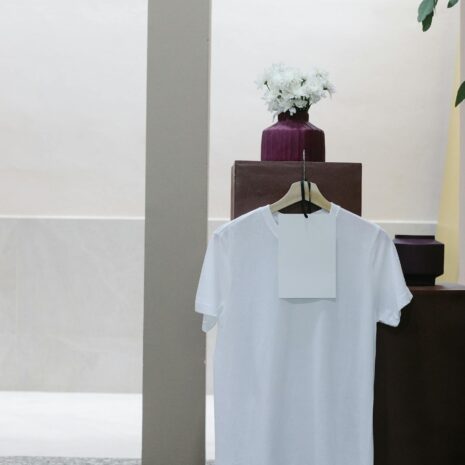 White t shirt with blank label hanging on counter in modern clothes shop