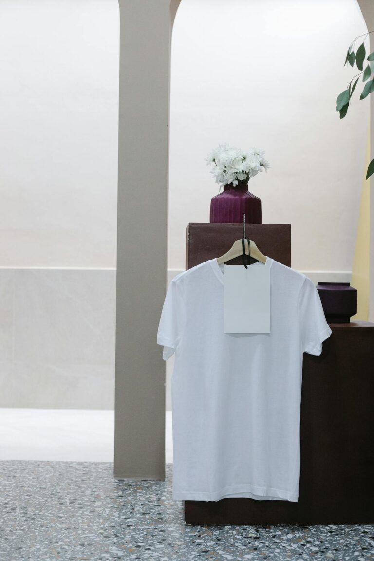 White t shirt with blank label hanging on counter in modern clothes shop