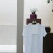 White t shirt with blank label hanging on counter in modern clothes shop